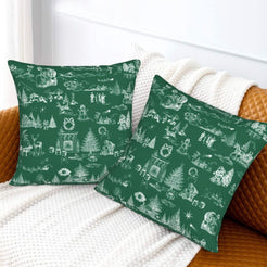 White on green classic Christmas town toile velvet pillow covers styled on a bed