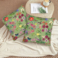 Tropical velvet pillow covers with sage butterflies and flowers, styled on a woven chair