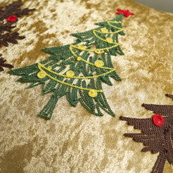 Close-up of Christmas tree embroidery on gold velvet fabric