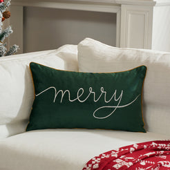 Green embroidered Merry velvet lumbar pillow cover styled on a white sofa