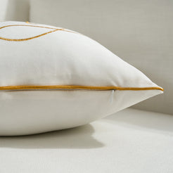 Hidden zipper and gold piped edge detail on an ivory velvet lumbar pillow cover