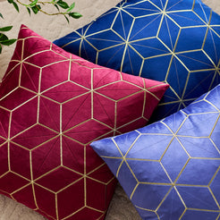 Close-up of raised gold stitching on embroidered velvet pillow cover with burgundy and blue gold geometric lines