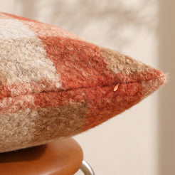 Hidden zipper and edge close-up of bouclé-textured polyester pillow cover with rust orange plaid