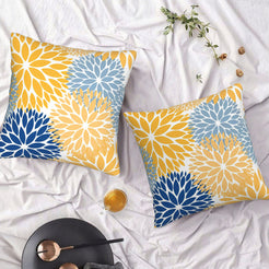 Set of two water-resistant pillow covers with yellow and blue chrysanthemum pattern, styled on a bed
