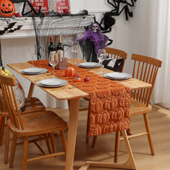 Orange raised-pumpkin table runner in a Halloween dining room setting