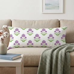 Long lumbar pillow cover with purple block-print-inspired floral sprigs, styled on a cream sofa