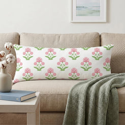 Long lumbar pillow cover with pink block-print-inspired floral sprigs, styled on a cream sofa