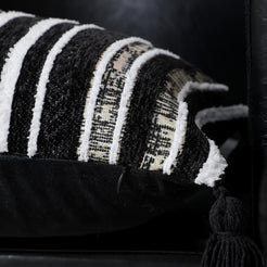 Side profile of black and ivory striped chenille polyester pillow cover with tassel