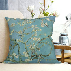 short-pile plush polyester pillow cover with white blossoming branches on a pale blue background, shown on a cream sofa