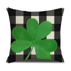 Short-pile plush pillow cover with a green shamrock on black gingham, shown on white