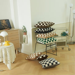 Assorted checkerboard faux fur pillow covers arranged around a chair