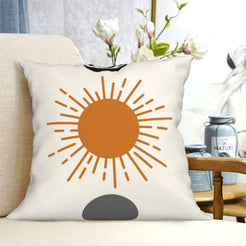 short-pile plush polyester pillow cover with orange sun with black eye and gray semicircle, shown on a cream sofa