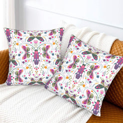 Folk butterfly velvet pillow covers with white butterflies and colorful flowers, styled on a woven chair