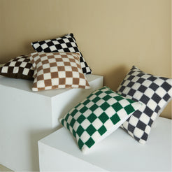 Black, green, brown and navy checkerboard faux fur pillow covers in a room