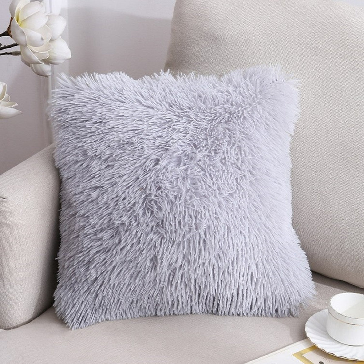Faux-fur plush polyester pillow cover with light gray long-pile texture, styled on a gray chair
