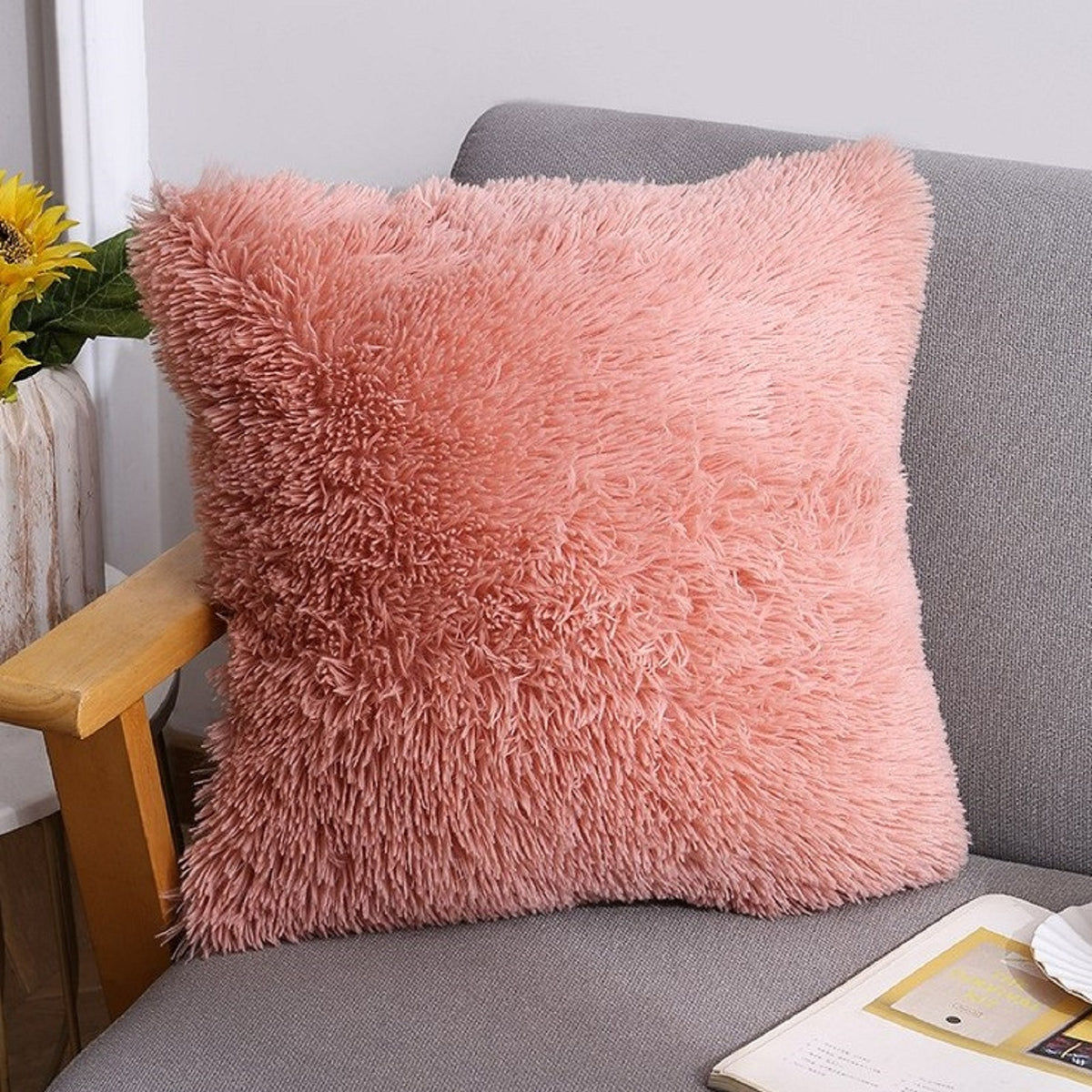 Faux-fur plush polyester pillow cover with coral pink long-pile texture, styled on a gray chair