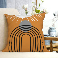 short-pile plush polyester pillow cover with black arch and gray circle on orange, shown on a cream sofa