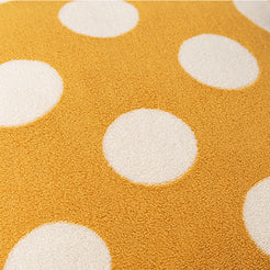 Close-up of loop-pile surface on loop-pile textured polyester pillow cover with raised white polka dots on mustard yellow
