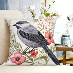short-pile plush polyester pillow cover with gray bird among pink flowers and berries, shown on a cream sofa