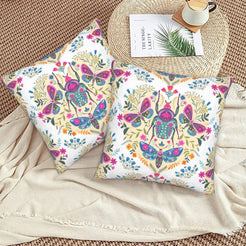 Folk butterfly velvet pillow covers with white folk beetle and butterfly motifs, styled on a woven chair