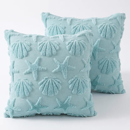Two light blue polyester pillow covers with raised seashell and starfish motifs