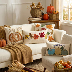 Embroidered polyester canvas pillow covers with autumn leaf designs, styled on a cream sofa