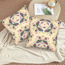 Folk butterfly velvet pillow covers with beige circular butterfly motifs, styled on a woven chair
