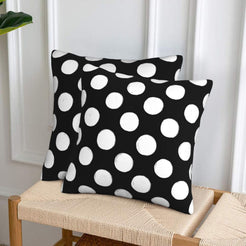 Black polka dot velvet pillow covers styled on a woven chair