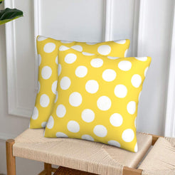Yellow and white polka dot velvet pillow covers styled on a woven chair
