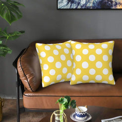Yellow and white polka dot velvet pillow covers styled on a sofa