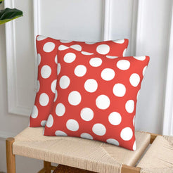 Coral red polka dot velvet pillow covers styled on a woven chair