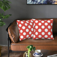 Coral red polka dot velvet pillow covers styled on a sofa