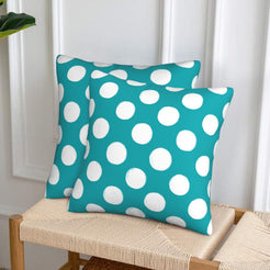 Teal polka dot velvet pillow covers styled on a woven chair