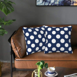 Navy blue polka dot velvet pillow covers styled on a sofa