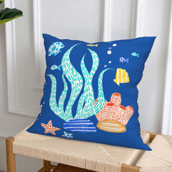 Short-pile plush polyester pillow cover with blue coral, shells and starfish print, styled on a woven chair
