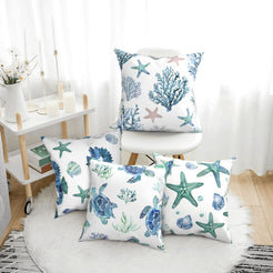 Short-pile plush polyester pillow covers with blue watercolor sea life prints, arranged beside a white chair