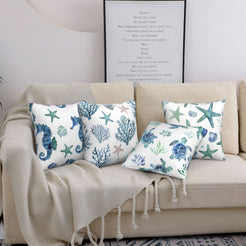 Short-pile plush polyester pillow covers with blue watercolor sea life prints, styled on a cream sofa