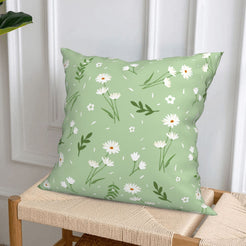 short-pile plush polyester pillow cover with small white daisies and leafy sprigs on sage, styled on a woven chair