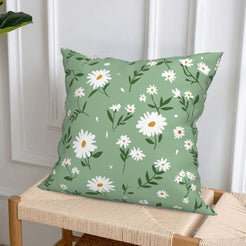 short-pile plush polyester pillow cover with white daisies and leafy sprigs on green, styled on a woven chair