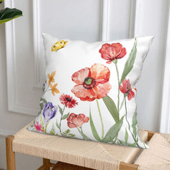 Short-pile plush pillow covers with red poppies and meadow flowers, styled on a woven chair
