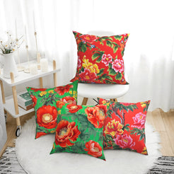 Short-pile plush pillow covers with bright red flowers on green, styled in a bright room