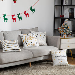 short-pile plush polyester pillow covers with black and gold Christmas prints, arranged on and beside a gray sofa