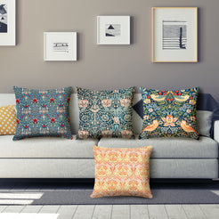 Short-pile plush polyester pillow covers with ornate floral and bird prints, arranged on a gray sofa