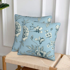 Set of two velvet pillow covers with light blue chrysanthemum print, styled on a woven chair