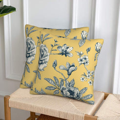 Set of two velvet pillow covers with mustard yellow rose spray, styled on a woven chair