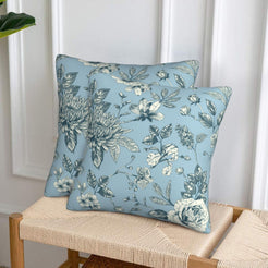 Set of two velvet pillow covers with light blue dense rose and chrysanthemum print, styled on a woven chair