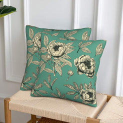 Set of two velvet pillow covers with green peony print, styled on a woven chair