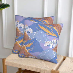 Set of two velvet pillow covers with periwinkle and tan mountains, styled on a woven chair
