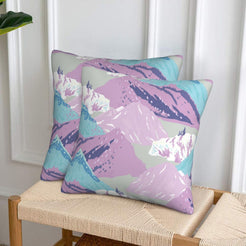 Set of two velvet pillow covers with lavender and aqua mountains, styled on a woven chair