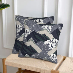 Set of two velvet pillow covers with charcoal and sage mountains, styled on a woven chair